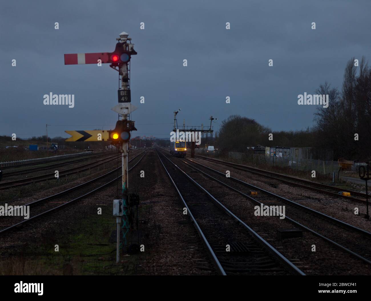 Semaphore distant railway signal with a approaching train at Barnetby, UK Stock Photo