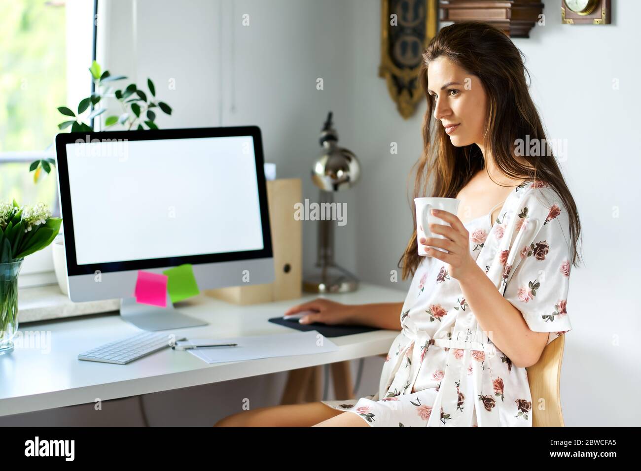 woman in pajamas working remotely at home during a pandemic Stock Photo