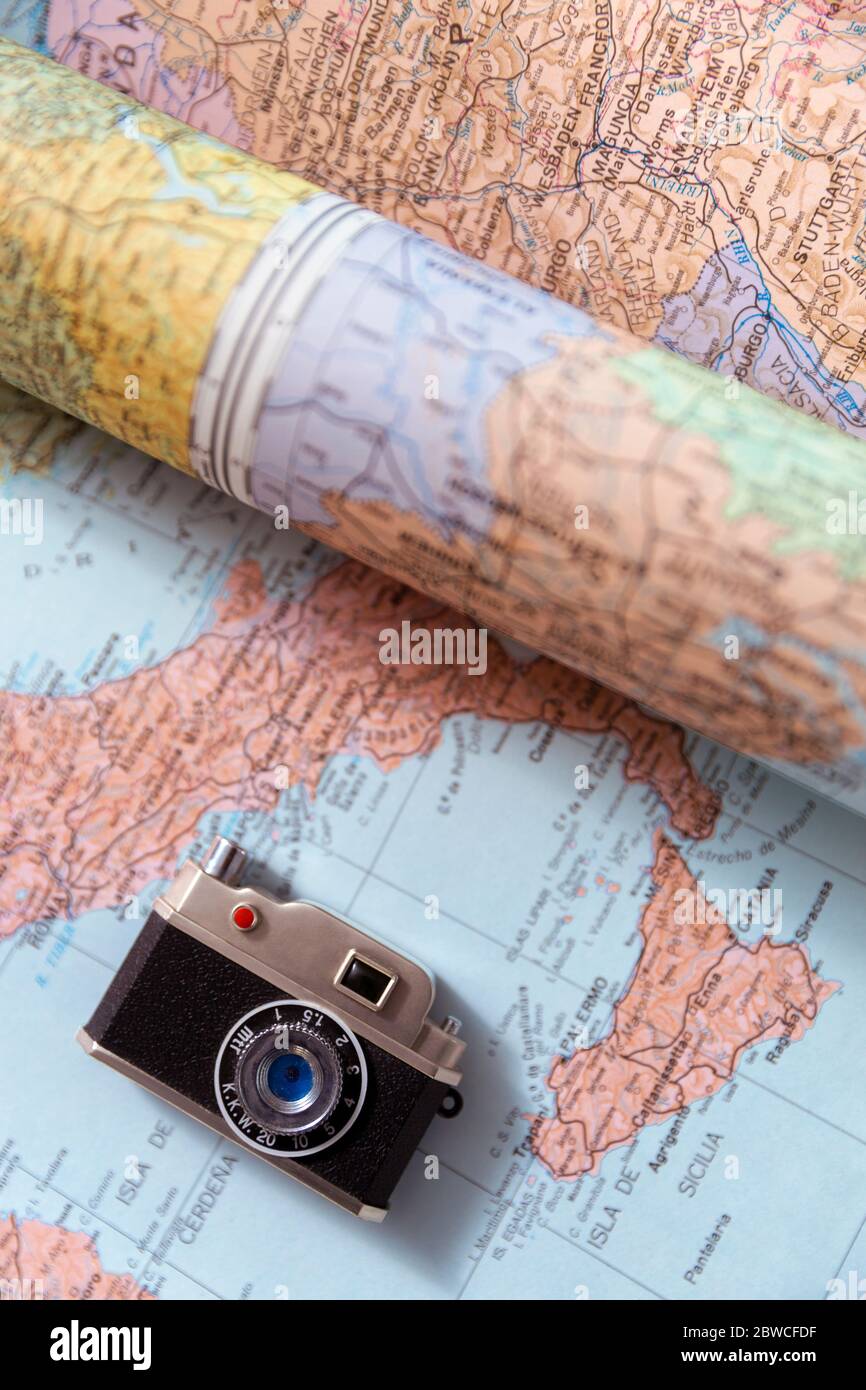 Toy photo camera miniature placed on world map. Top view. Travel, tourism and vacation concept. Stock Photo