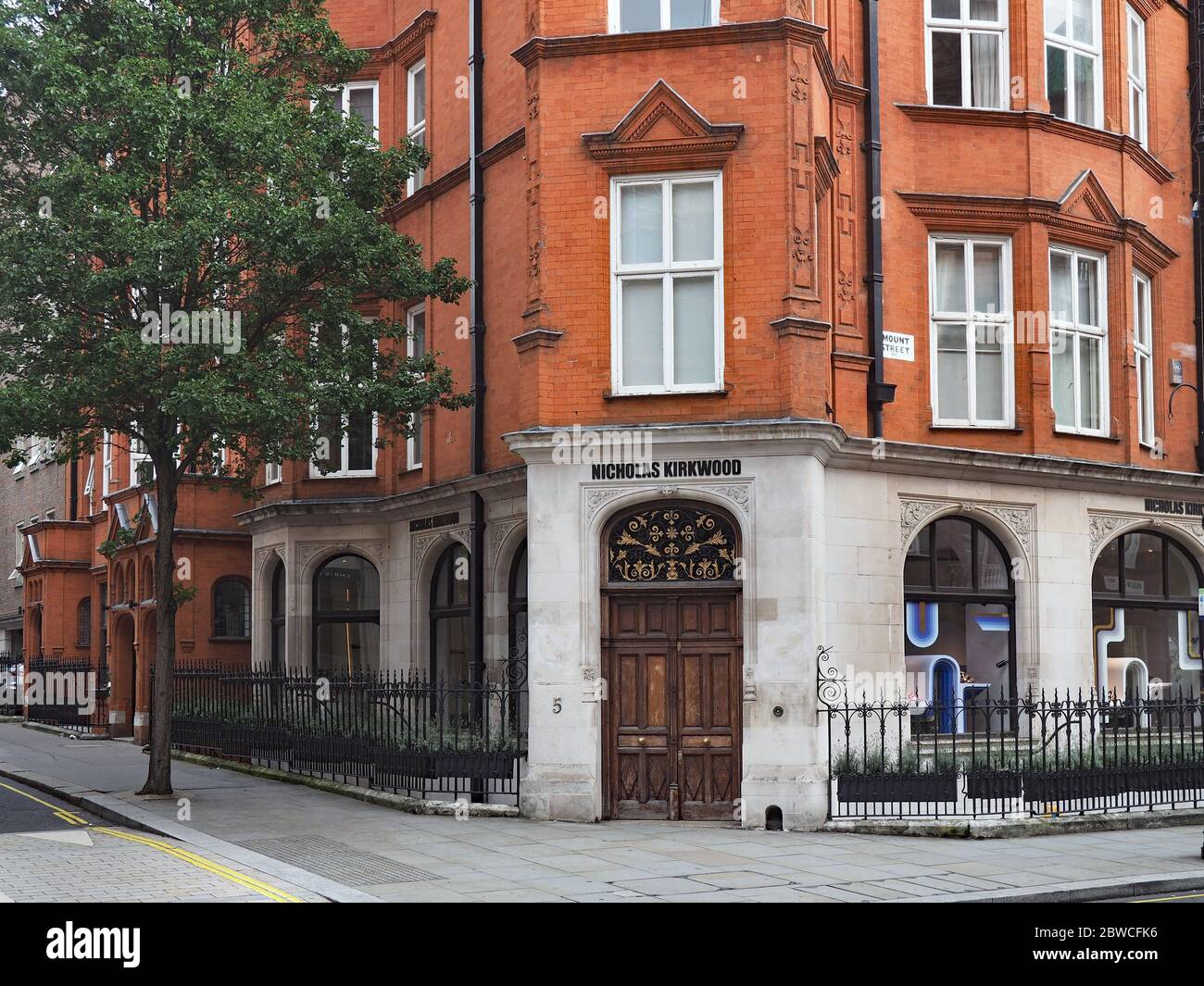 an old fashioned apartment building in the Mayfair district of London with a shop at ground level Stock Photo