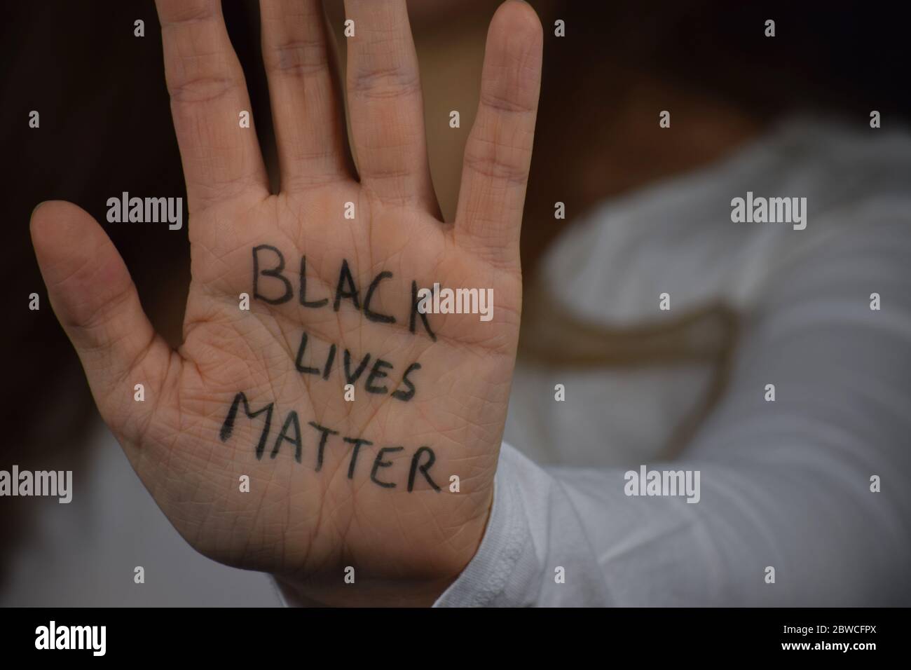 Caucasien woman holding her palm with text Black Lives Matter in support of peaceful protests against police brutality and racism Stock Photo