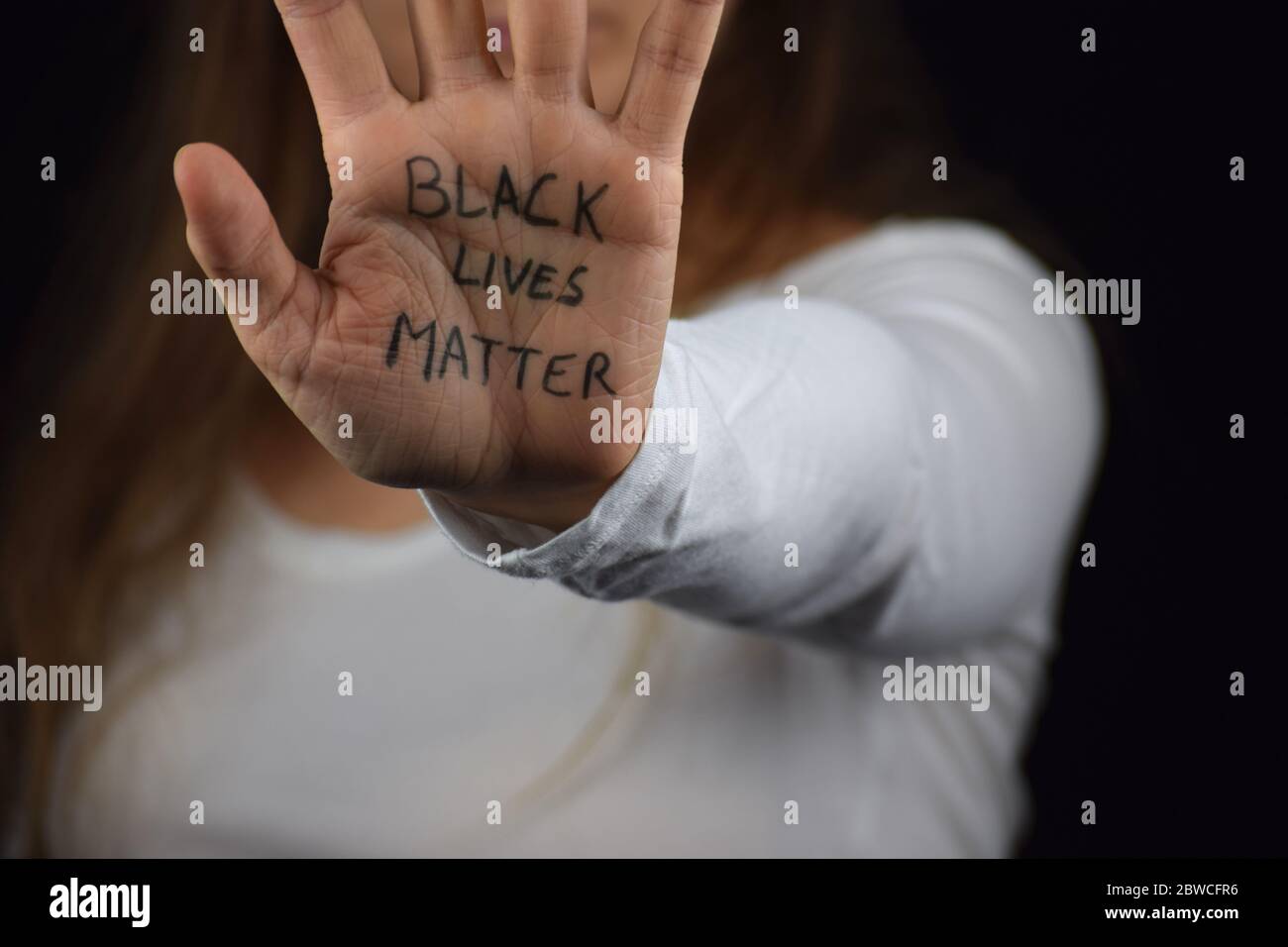 Caucasien woman holding her palm with text Black Lives Matter in support of peaceful protests against police brutality and racism Stock Photo