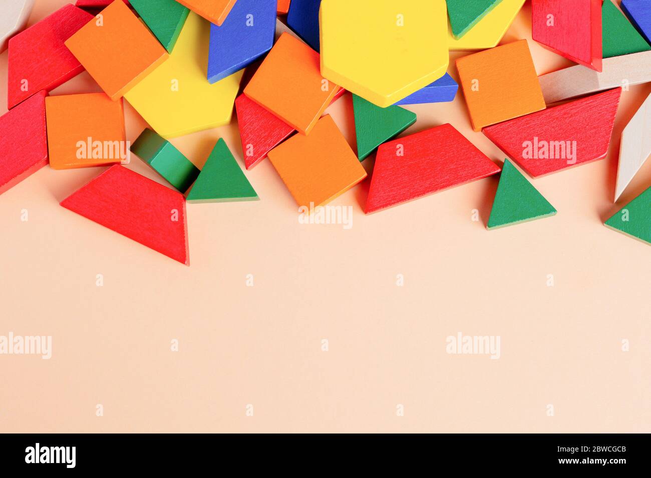 Wooden colored blocks poured out of box on a beige background. Shallow ...