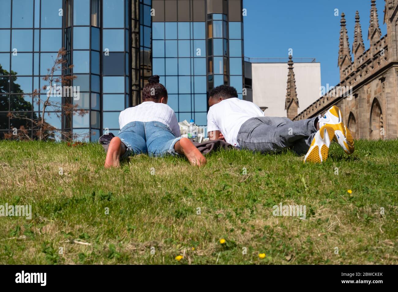 Glasgow, Scotland, UK. 31st May, 2020. A couple lying on the grass at Clyde Street on a warm and sunny Sunday afternoon. The Scottish Government announced on 28th May an easing of the coronavirus lockdown rules. Credit: Skully/Alamy Live News Stock Photo