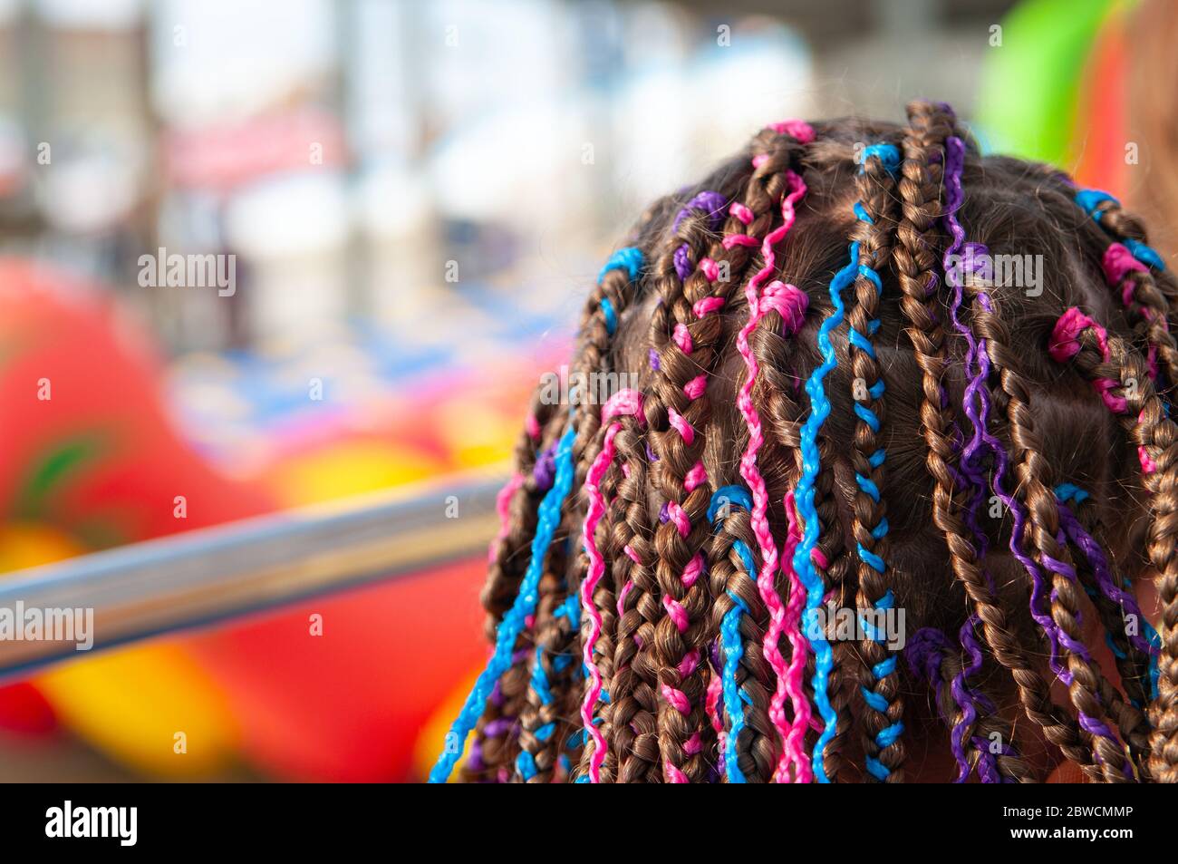 Teen girl's hair with small afro pigtails with bright multicolored ribbons Stock Photo