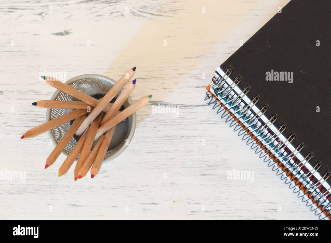 Pencil pot and a stack of notebooks flatlay Stock Photo