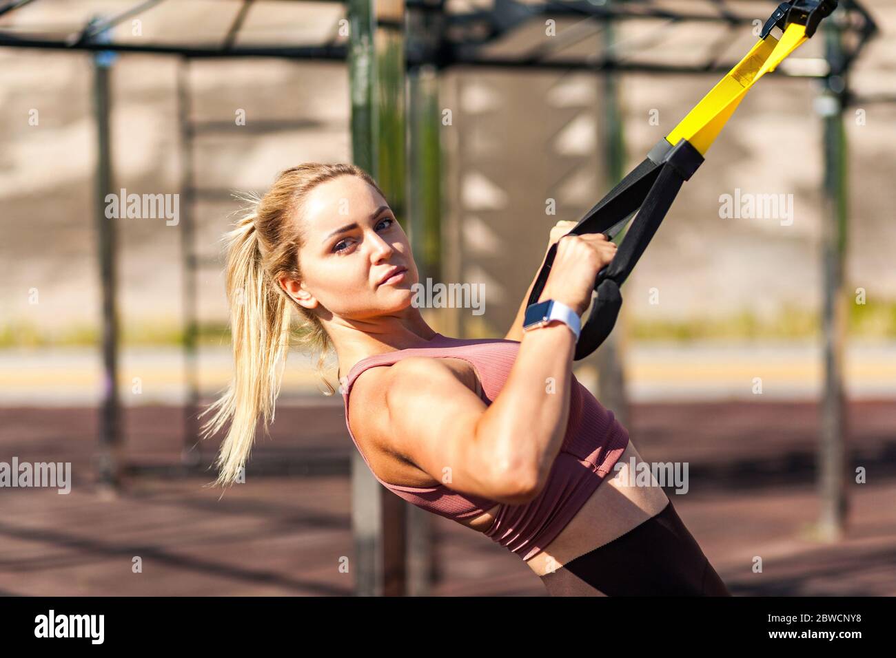 Closeup strong athlete blond woman training outdoor, pulling trx suspension  straps, doing upper body workouts for muscle build, fat burning, cardio im  Stock Photo - Alamy