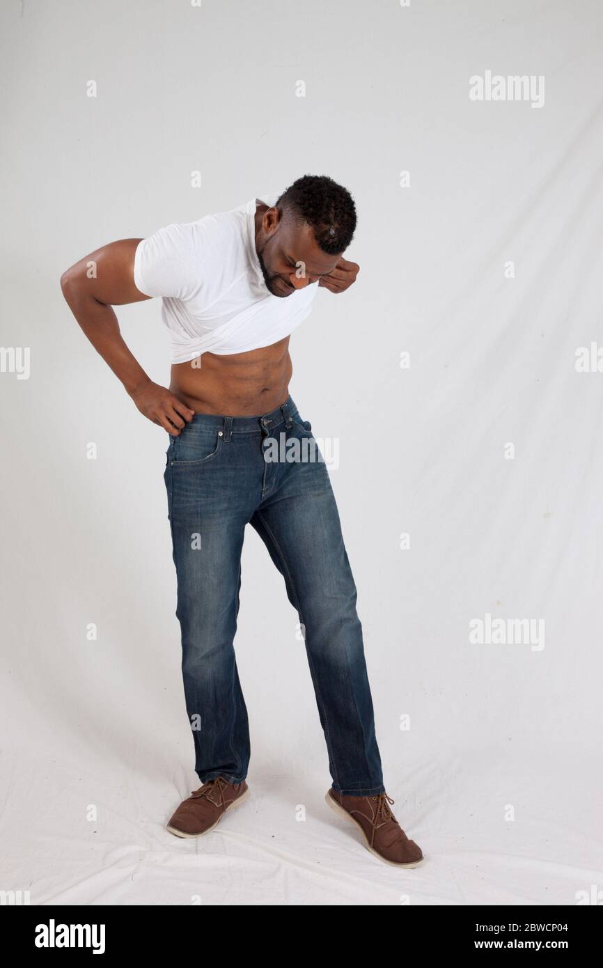 Black man pulling up his shirt Stock Photo Alamy
