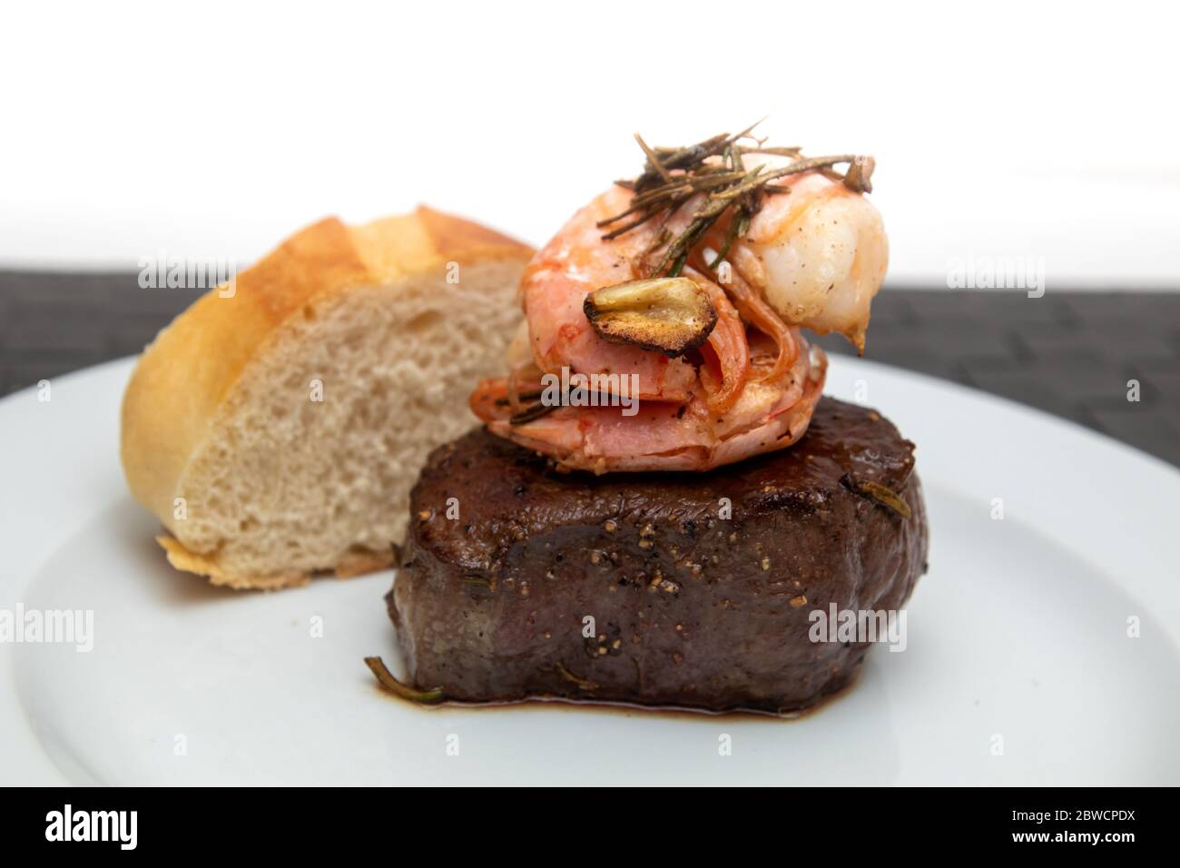 surf and turf, beef fillet with prawns and baguette Stock Photo - Alamy