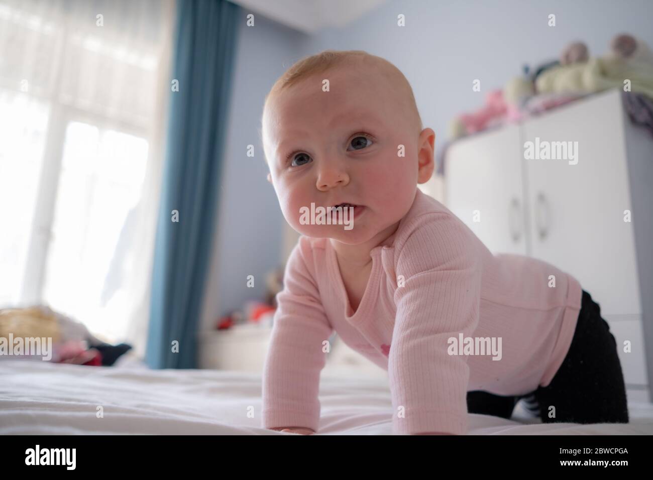 Cute baby girl standing on bed make funny faces, angry face, crying in the morning Stock Photo