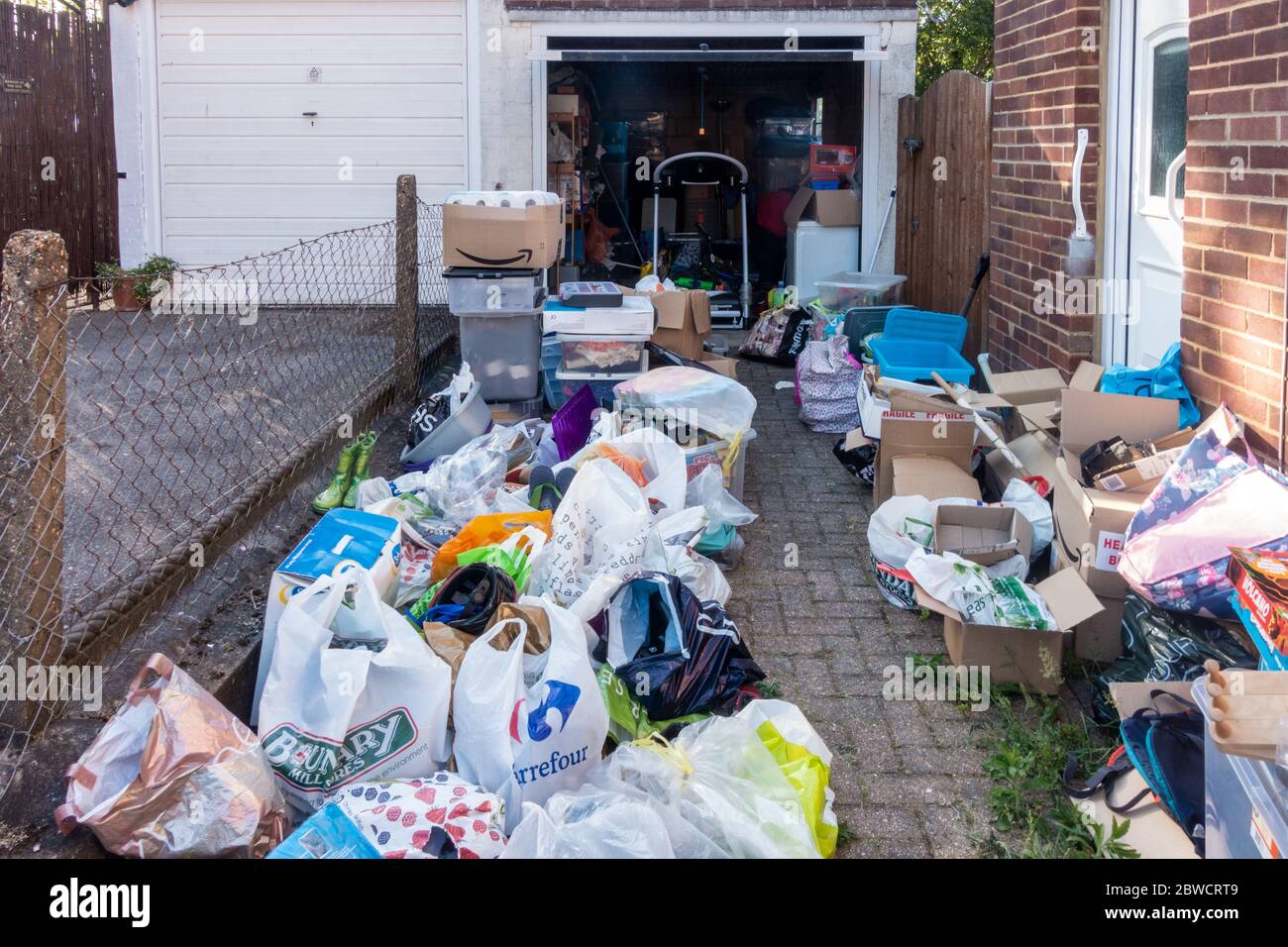 Clearing rubbish out of a residential garage. Sorting into piles to keep and throw away. Stock Photo