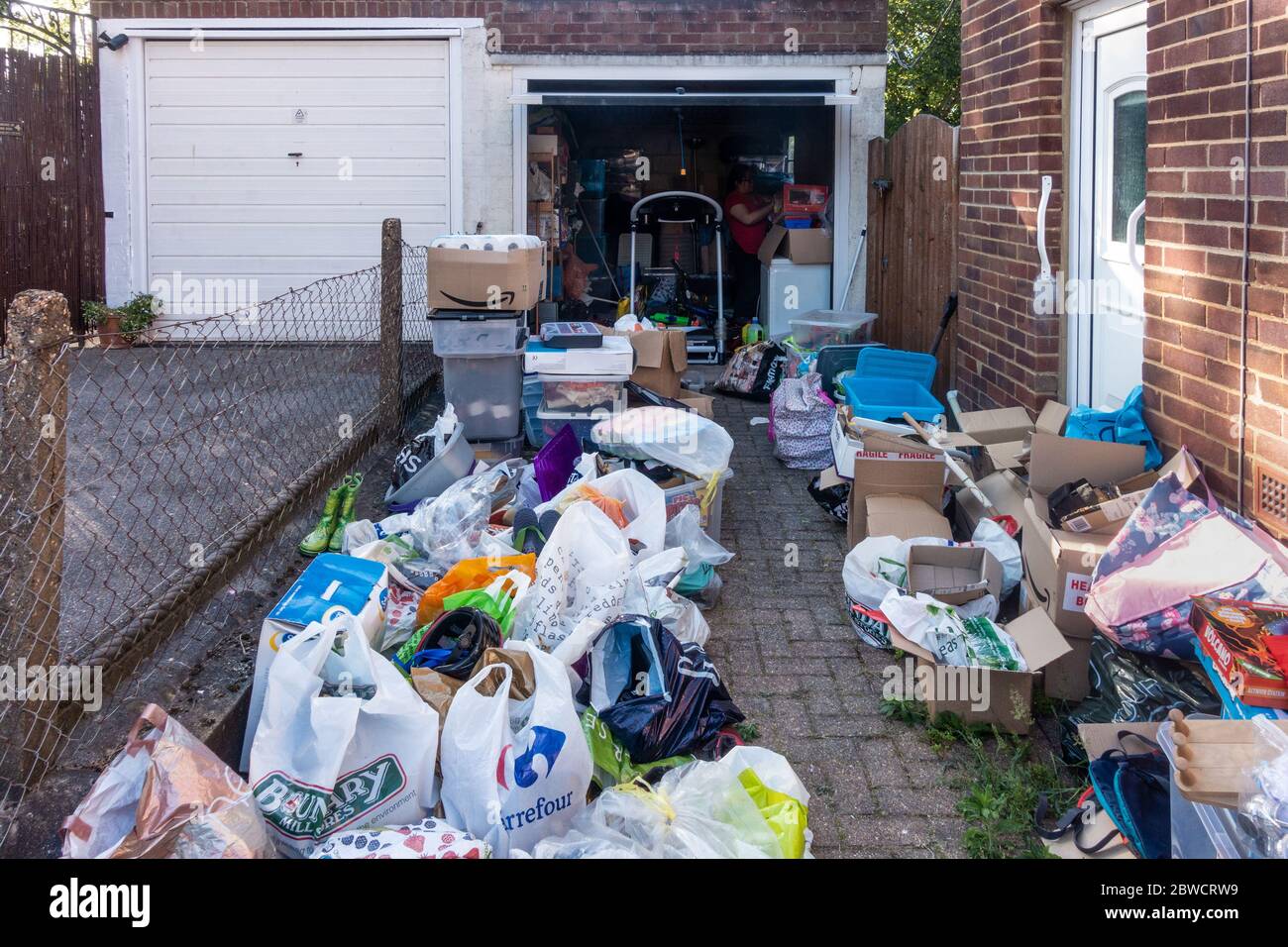 Clearing rubbish out of a residential garage. Sorting into piles to keep and throw away. Stock Photo