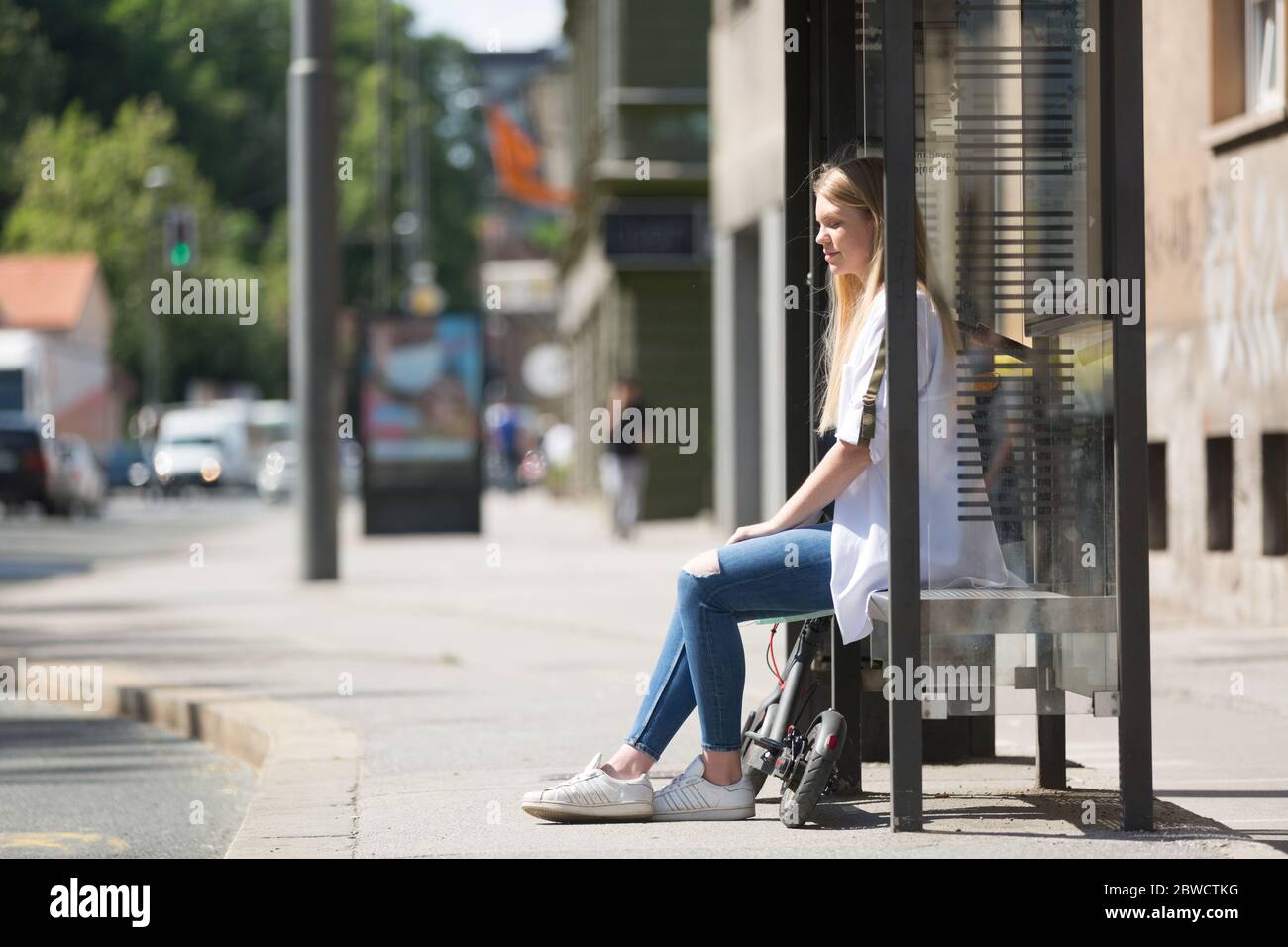 Casual caucasian teenager commuter with modern foldable urban electric