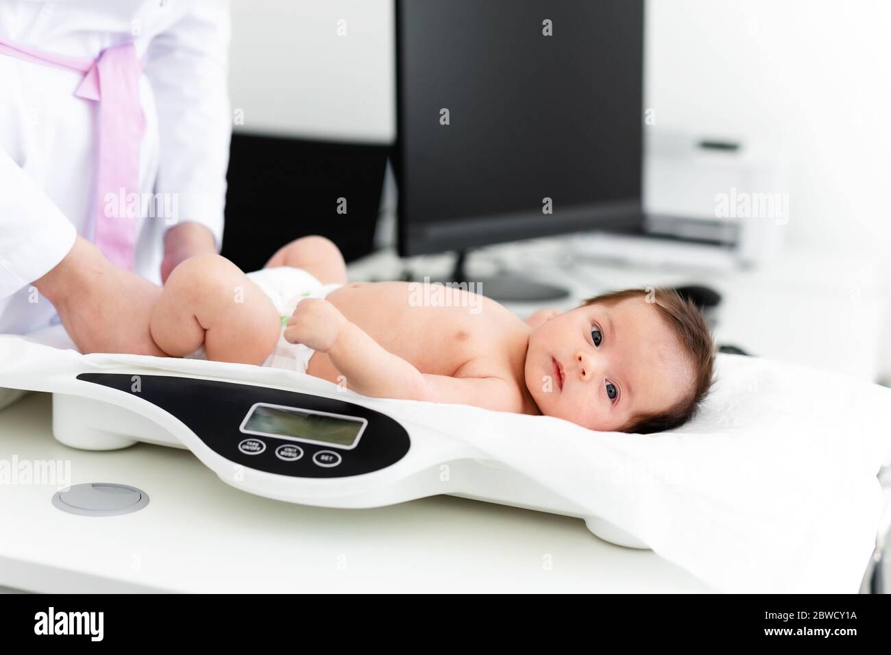 https://c8.alamy.com/comp/2BWCY1A/close-up-of-a-doctor-checking-weight-of-cute-little-baby-healthcare-concept-2BWCY1A.jpg