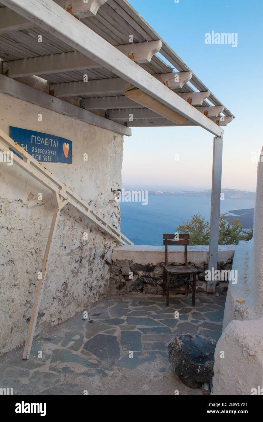 Old rotten traditional Greek wooden chair on a balcony overlooking the ...