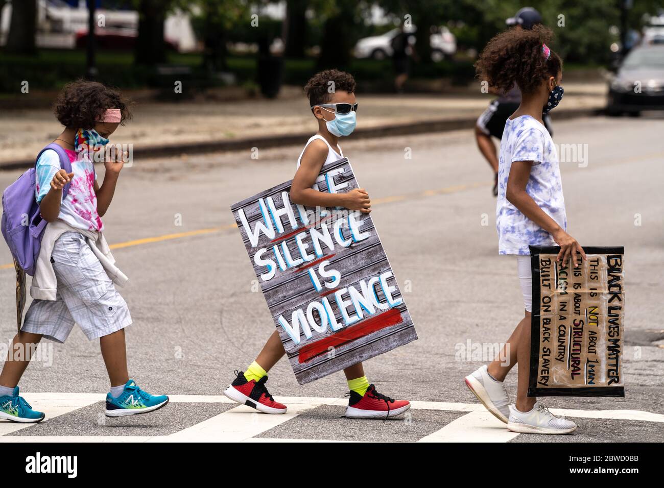 Charleston, United States. 31st May, 2020. Young protesters walks across a street holding signs following a peaceful demonstration over the death of George Floyd, along the historic Battery May 31, 2020 in Charleston, South Carolina. Floyd was choked to death by police in Minneapolis resulting in protests sweeping across the nation. Credit: Richard Ellis/Alamy Live News Stock Photo