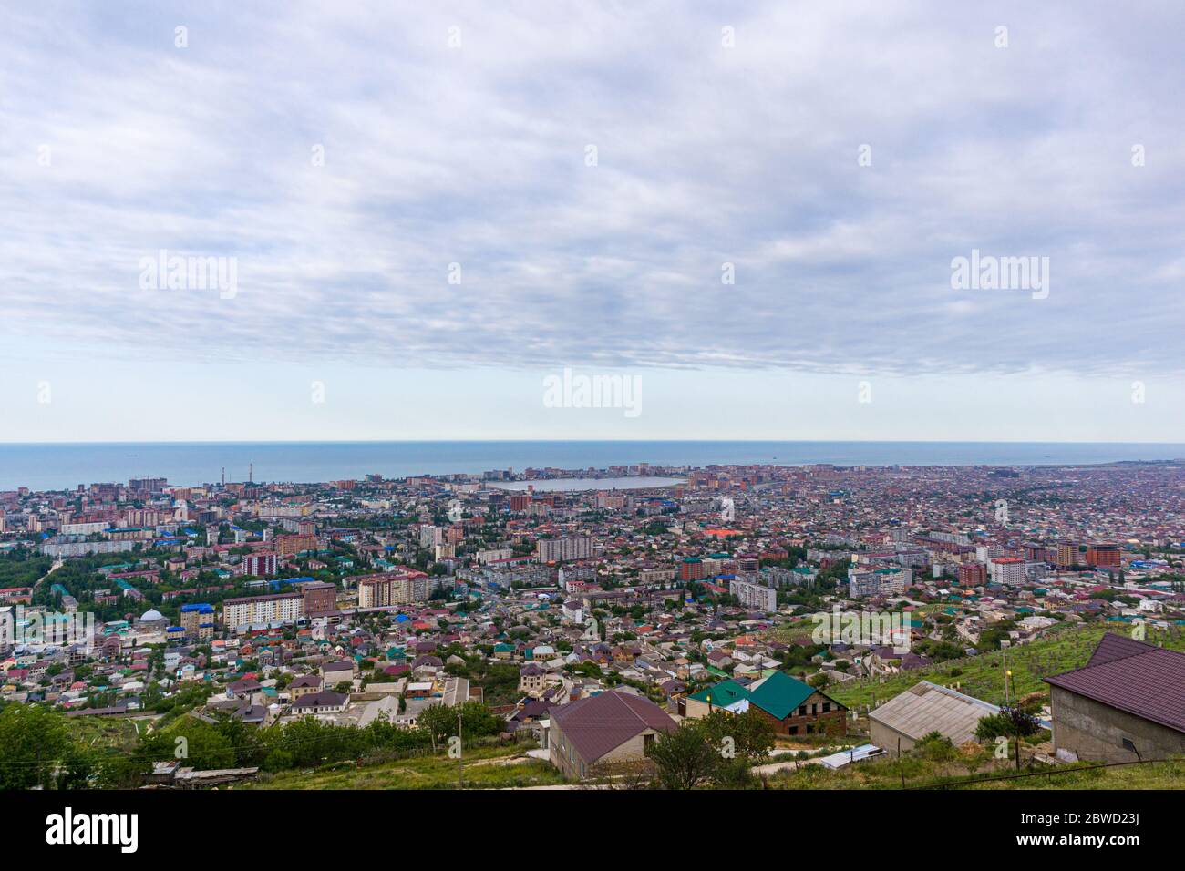 Overview of the seaside town from the mountain with cloudy sky background. Stock Photo