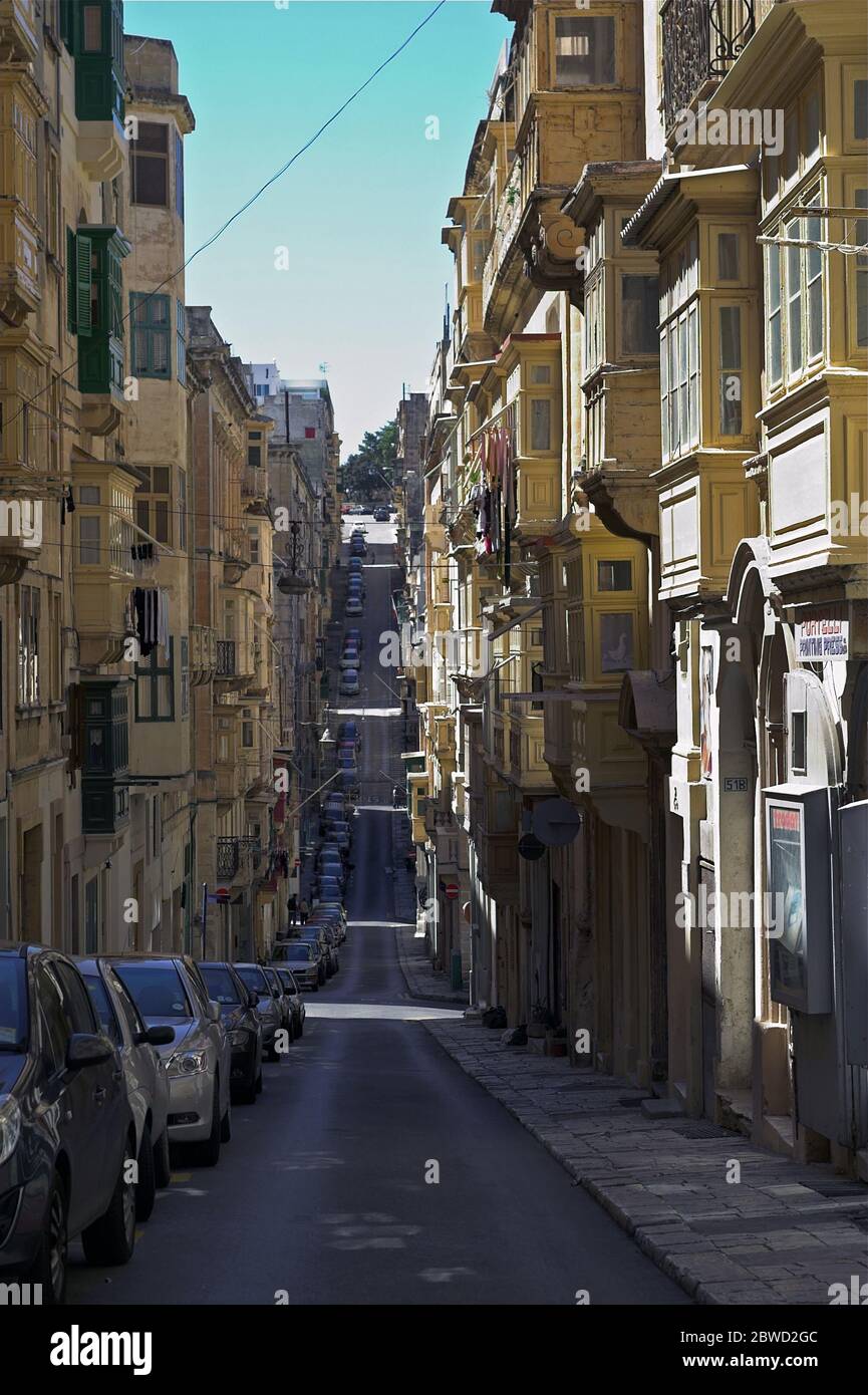 Malta, Valletta, A narrow street with tall tenements in the old town. Eine schmale Straße mit hohen Wohnungen in der Altstadt. Wąska ulica w centrum. Stock Photo