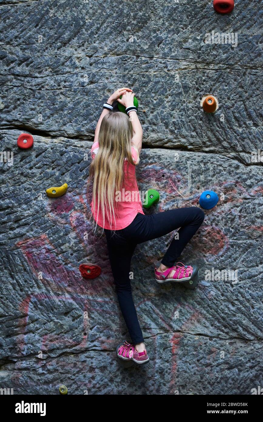 Girl having fun during rock climbing training on boulder wall Stock