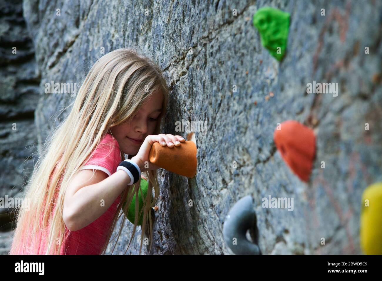 Girl having fun during rock climbing training on boulder wall Stock Photo
