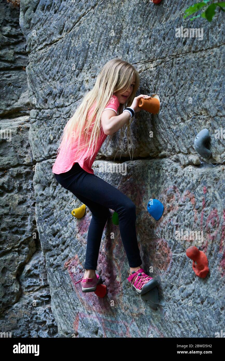 Girl having fun during rock climbing training on boulder wall Stock