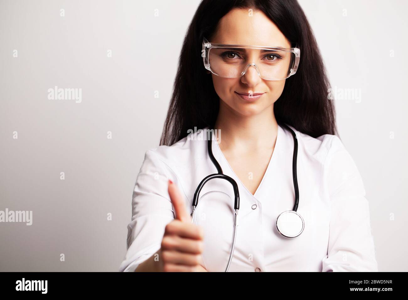 Portrait of a doctor with glasses and a white medical gown looking at