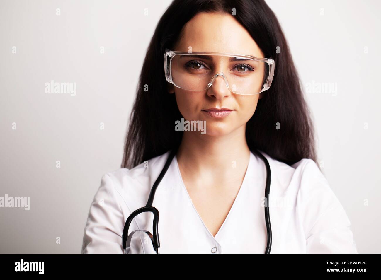 Portrait of a doctor with glasses and a white medical gown looking at