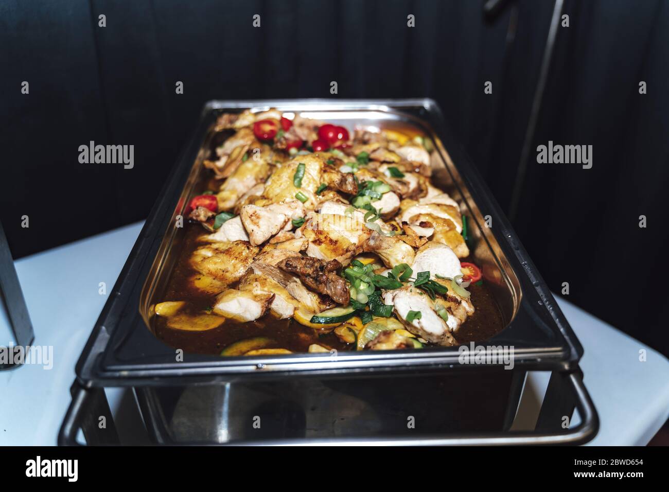 https://c8.alamy.com/comp/2BWD654/stainless-hotel-pan-on-food-warmer-with-roasted-meat-pieces-and-vegetable-self-service-buffet-table-celebration-party-birthday-or-wedding-concept-2BWD654.jpg