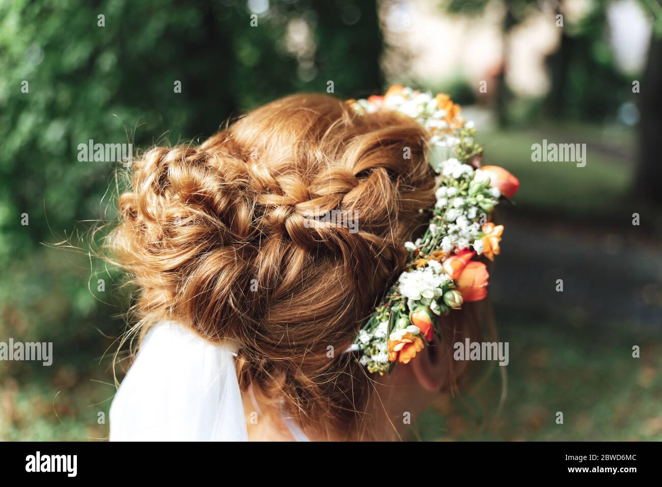 Bride hairstyle close up. Art of hairstylist with bridal flower headpiece. Outdoor background. Wedding day concept. Stock Photo