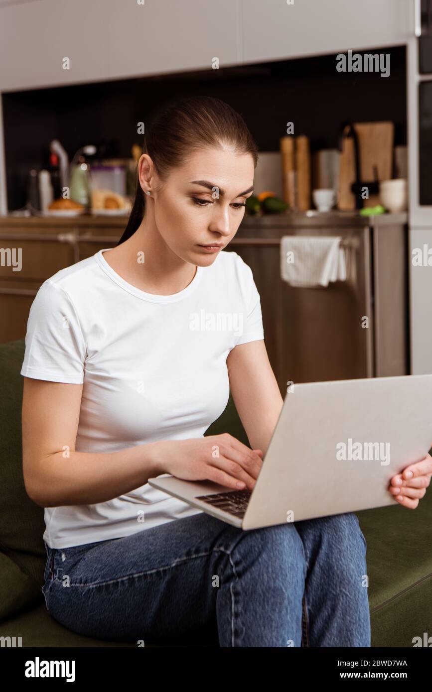 Beautiful woman using laptop on couch at home Stock Photo - Alamy