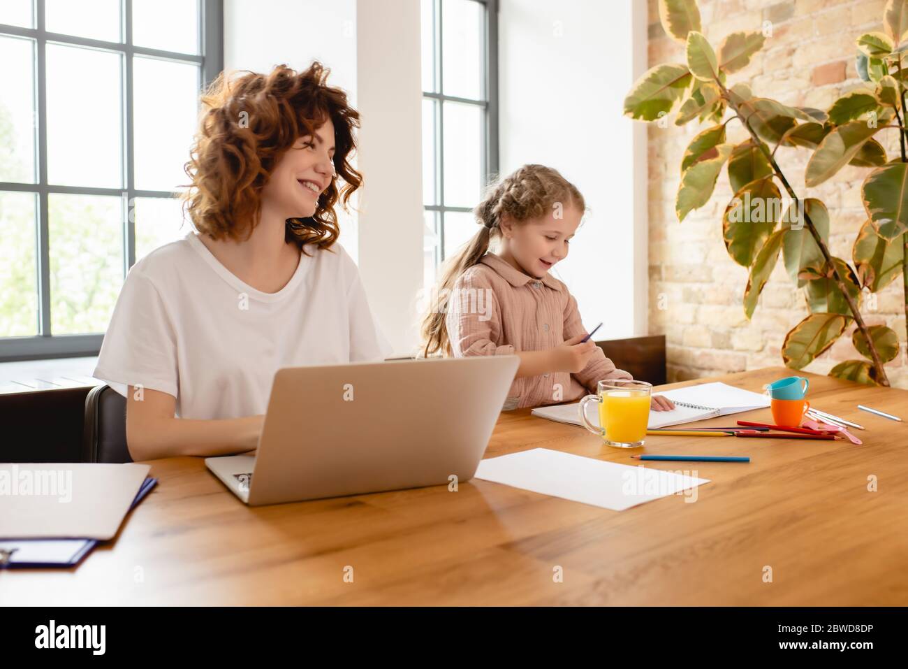 happy-daughter-drawing-while-freelancer-