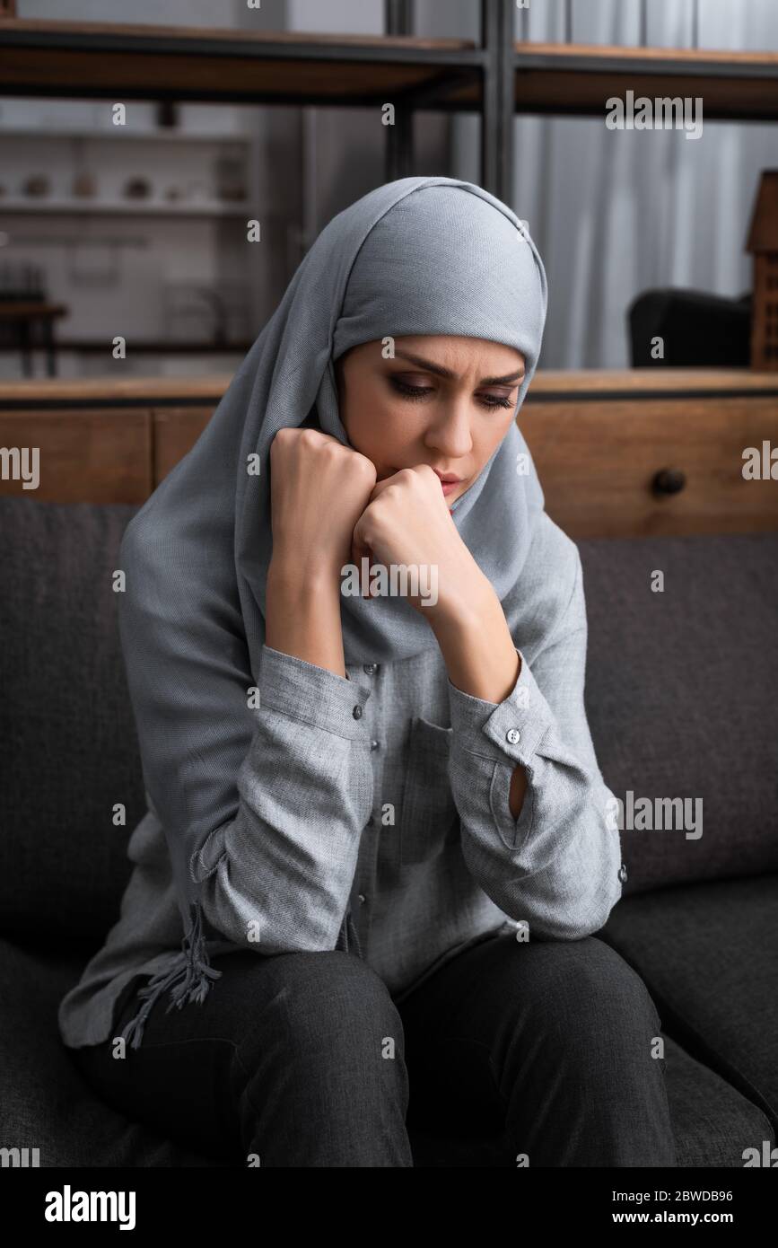 upset muslim woman in hijab sitting on sofa, domestic violence concept ...