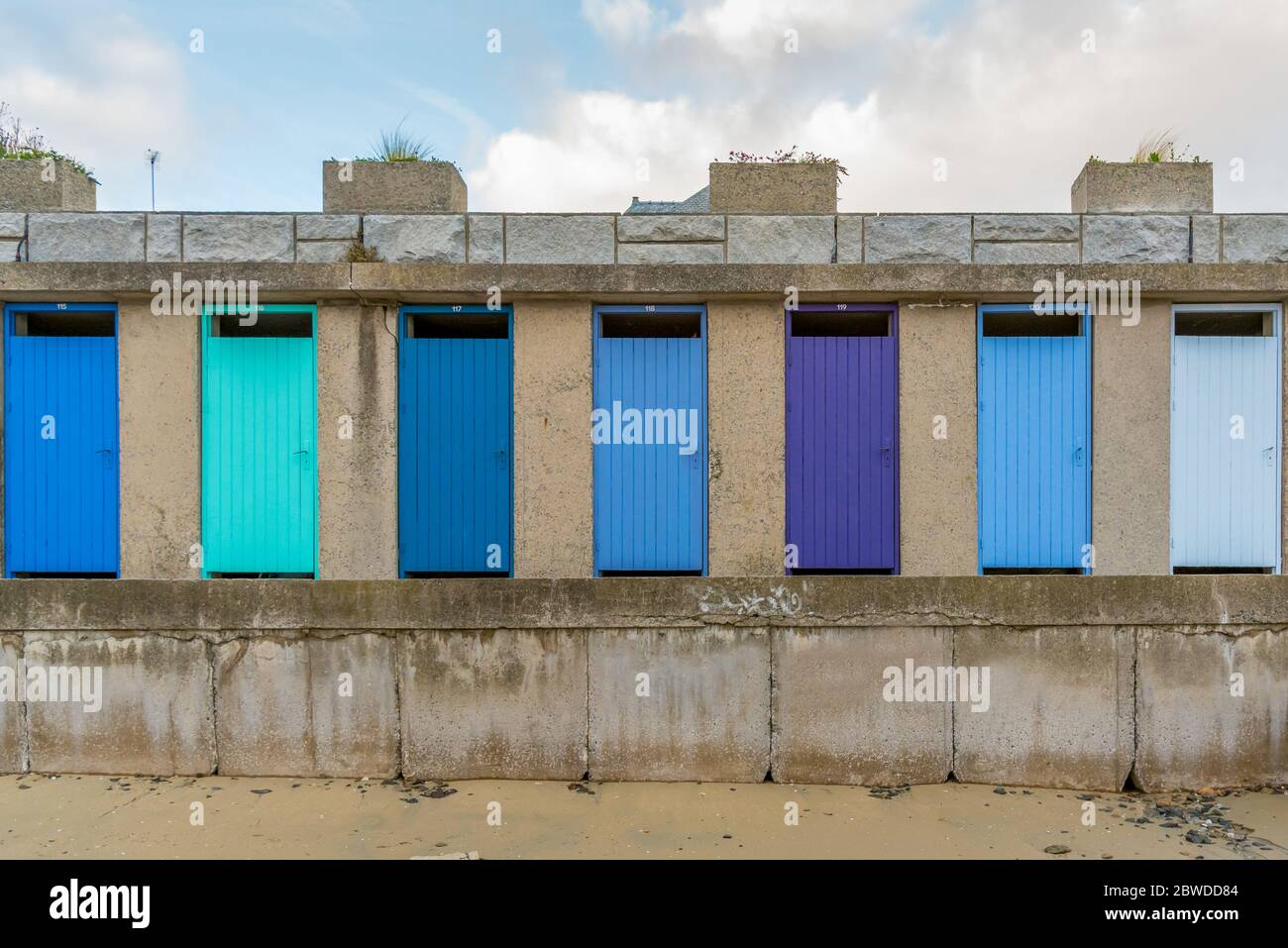 Row of colorful beach cabin wooden doors painted with different shades of blue Stock Photo