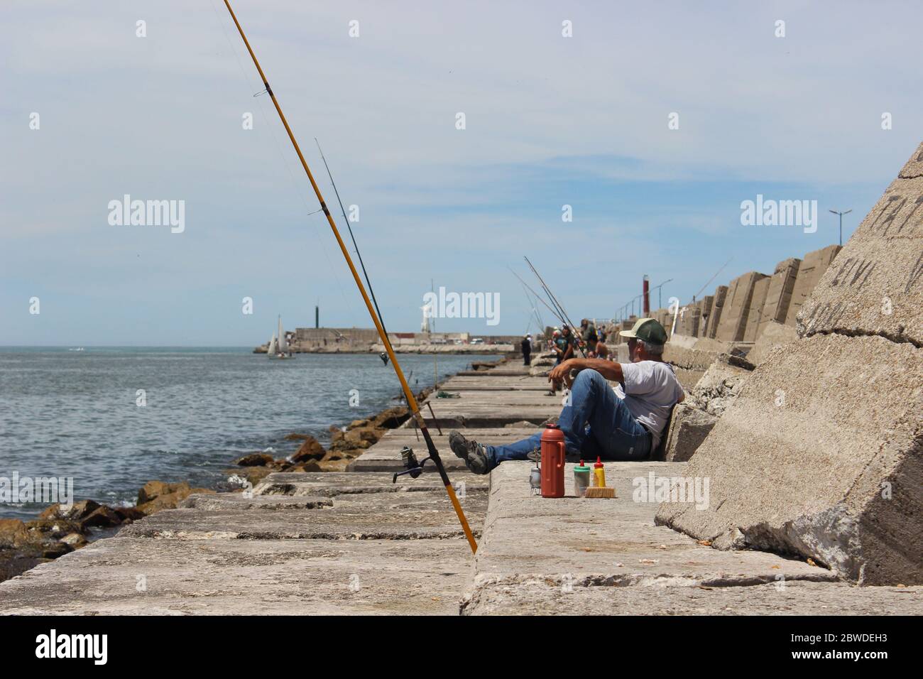 fishermen resting on the coast with Mate (Argentinean Tea) next to some stanks at the front and on the background we can see the statue of christ on t Stock Photo