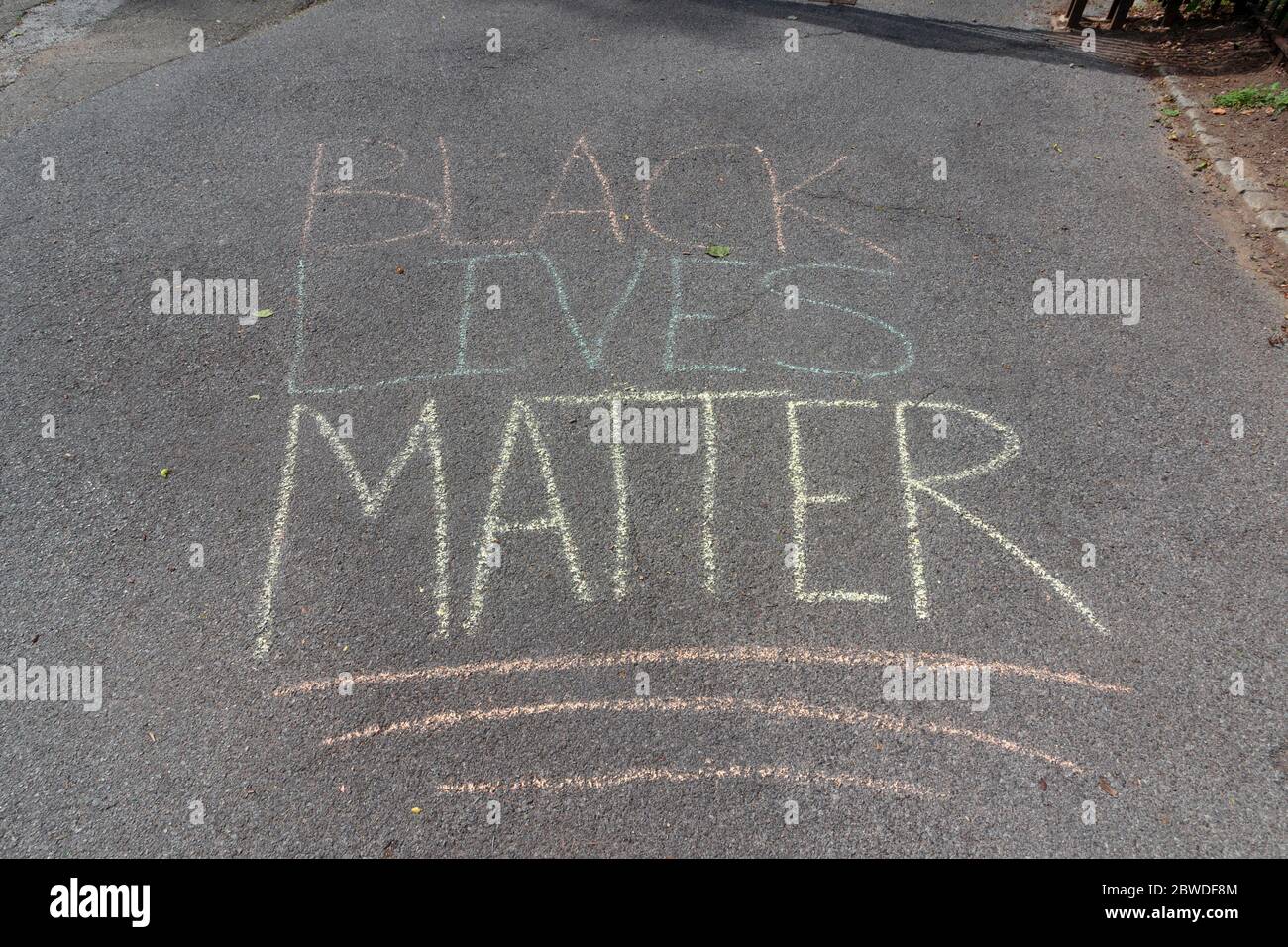 Black Lives Matter written in chalk on the pavement leading to the vigil or protest on the Cloisters Lawn in Fort Tryon Park Stock Photo