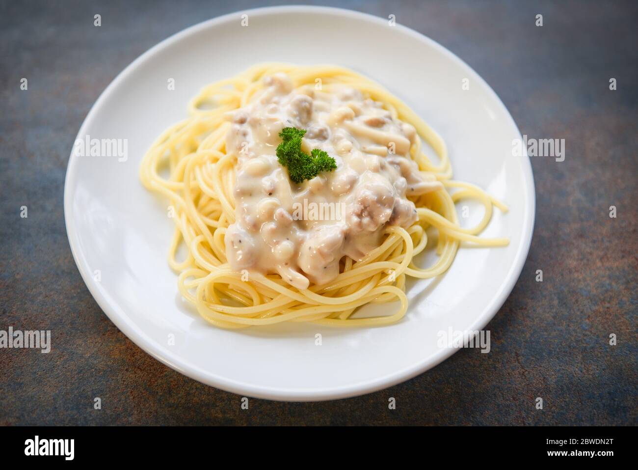 Spaghetti italian pasta served on white plate with parsley in the