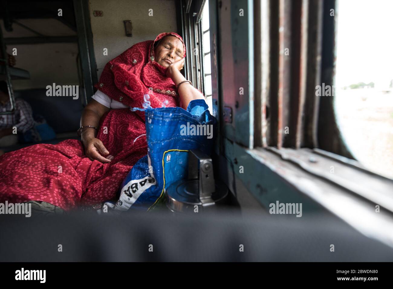 Woman looking out moving train window, second class train. Indian Railways. India. Stock Photo