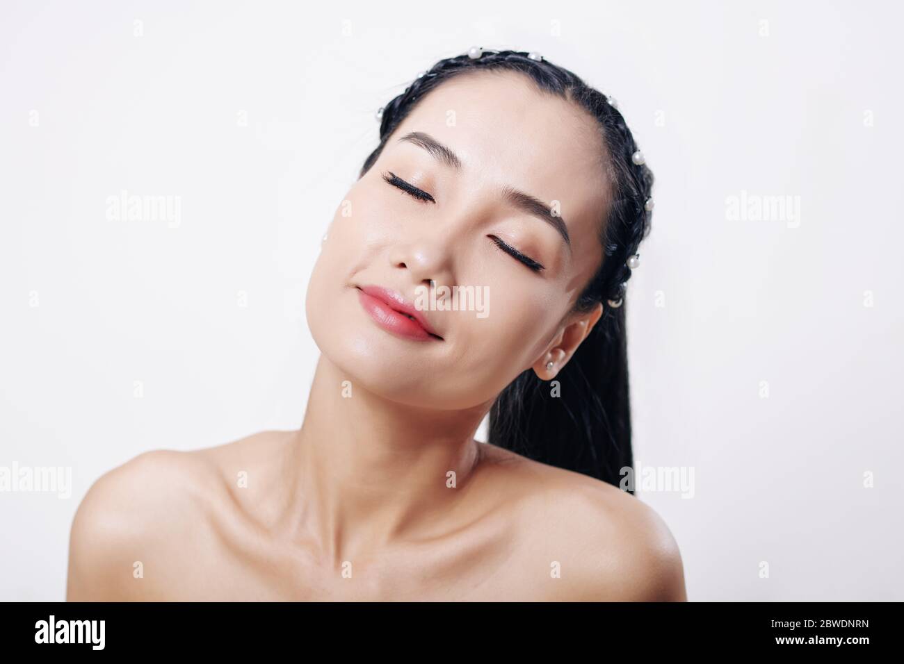 Portrait of young Vietnamese woman smiling with her eyes closed ...