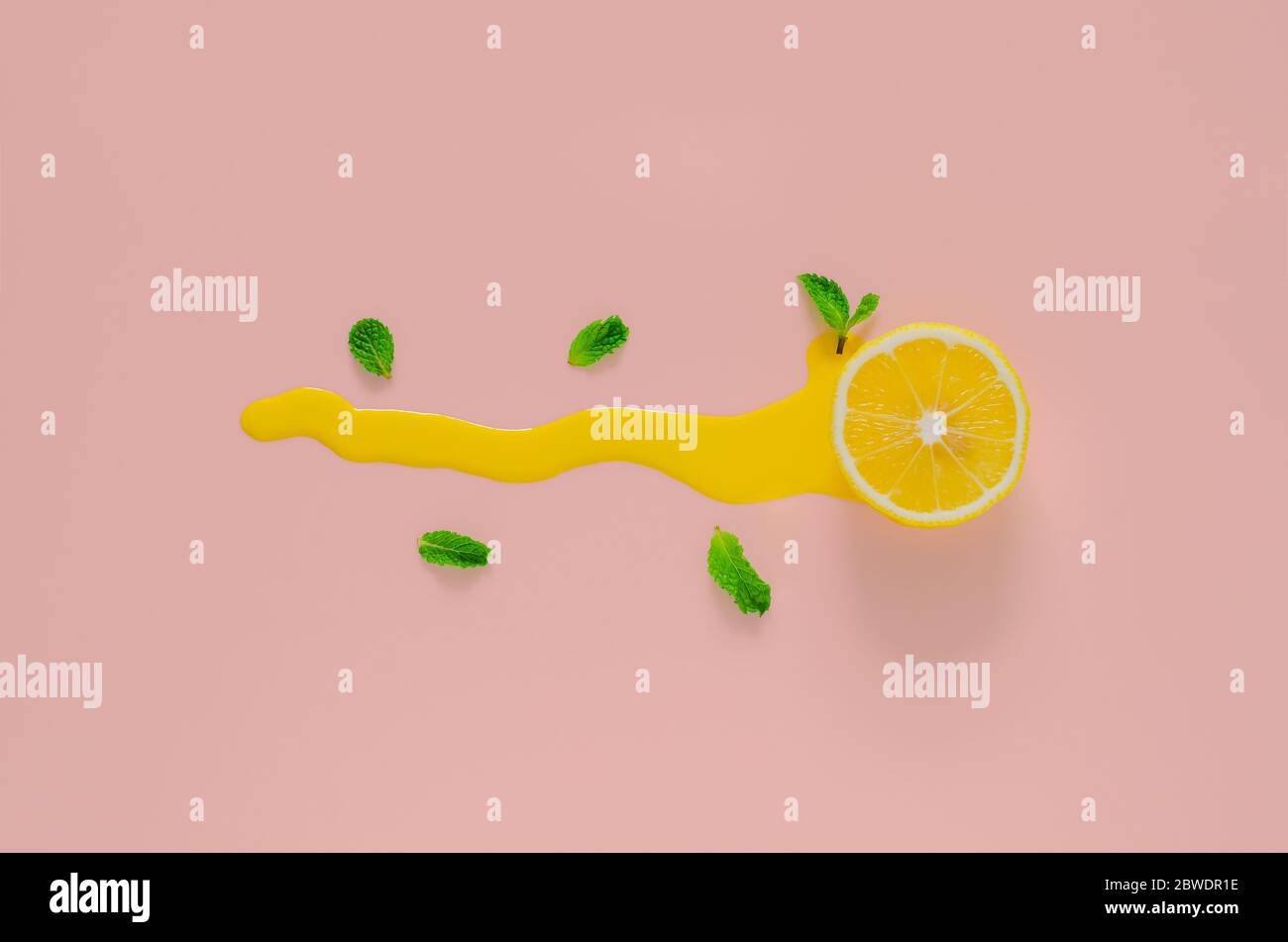 Slice lemon with mint leaves and yellow poster color that drop on pink background. Minimal summer concept. Stock Photo