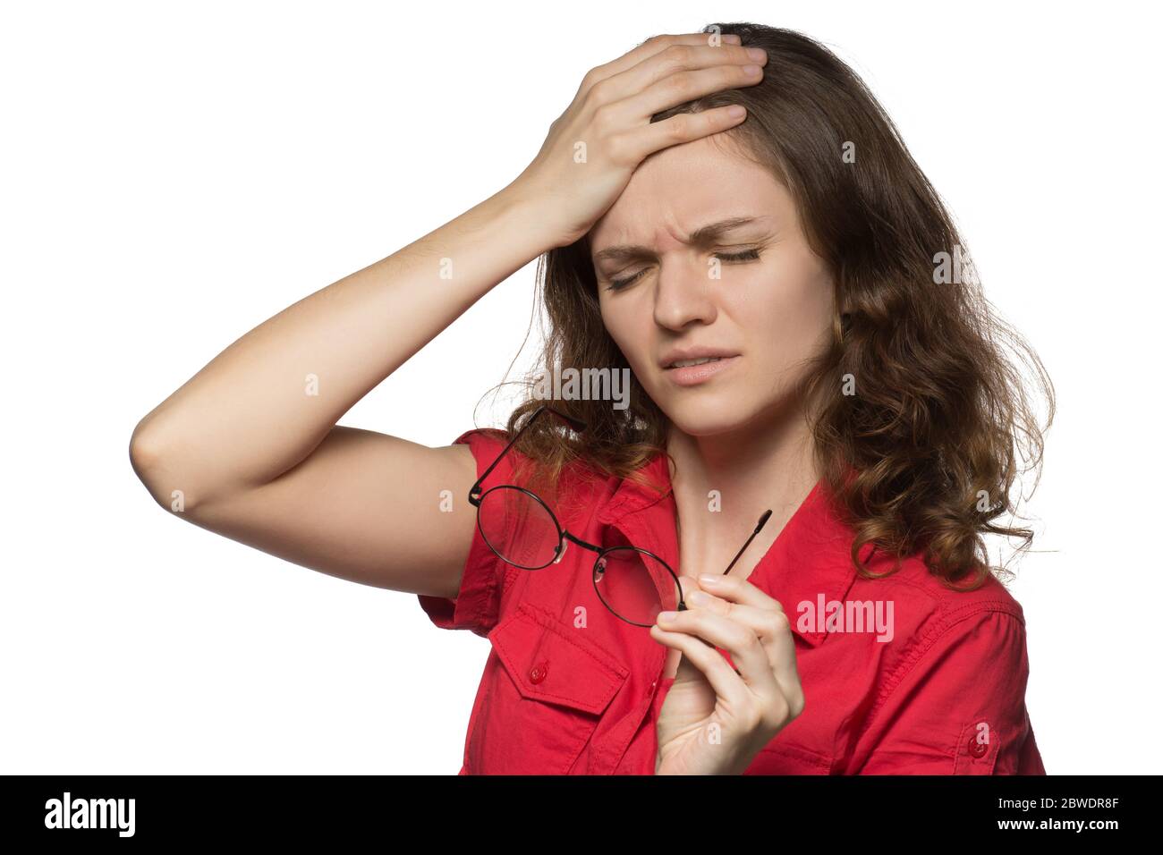 Beautiful young girl in a red shirt on a white background who has sore