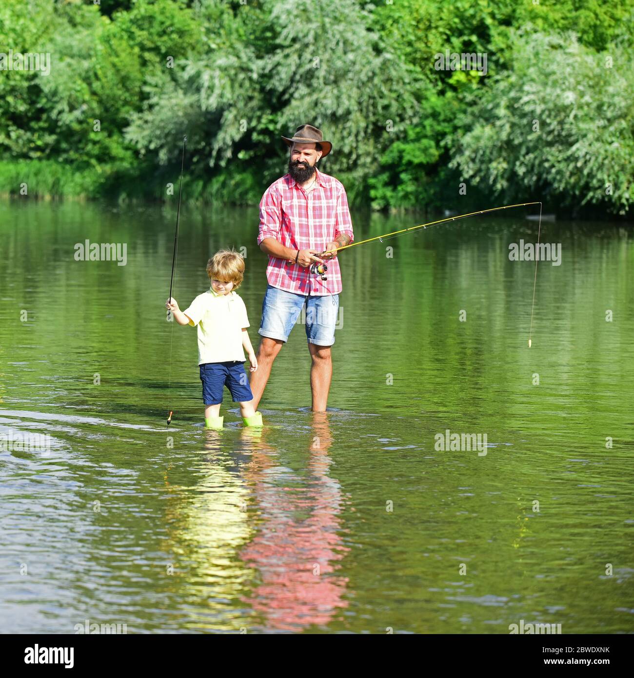 Father and son fishing. Father with his son on the river enjoying ...