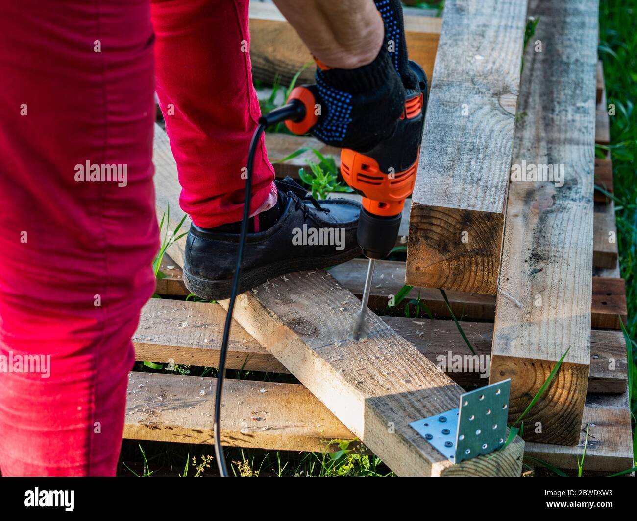 Making holes in a pine beam using an electric drill with wood drilling