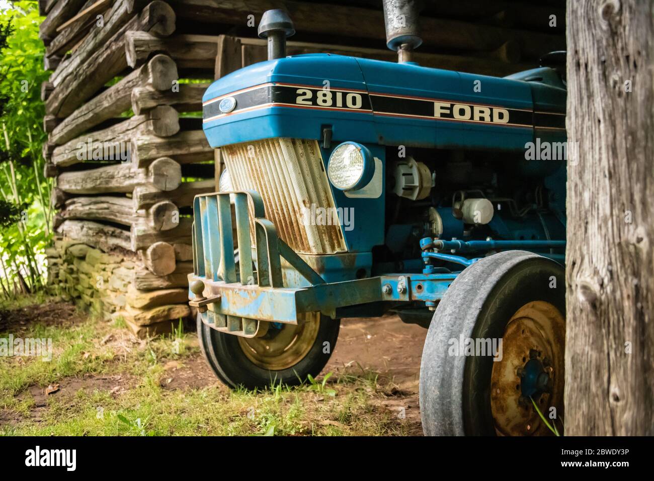 Ford tractor in a log barn at Ella-Springs in the Northeast Georgia Mountains. (USA) Stock Photo