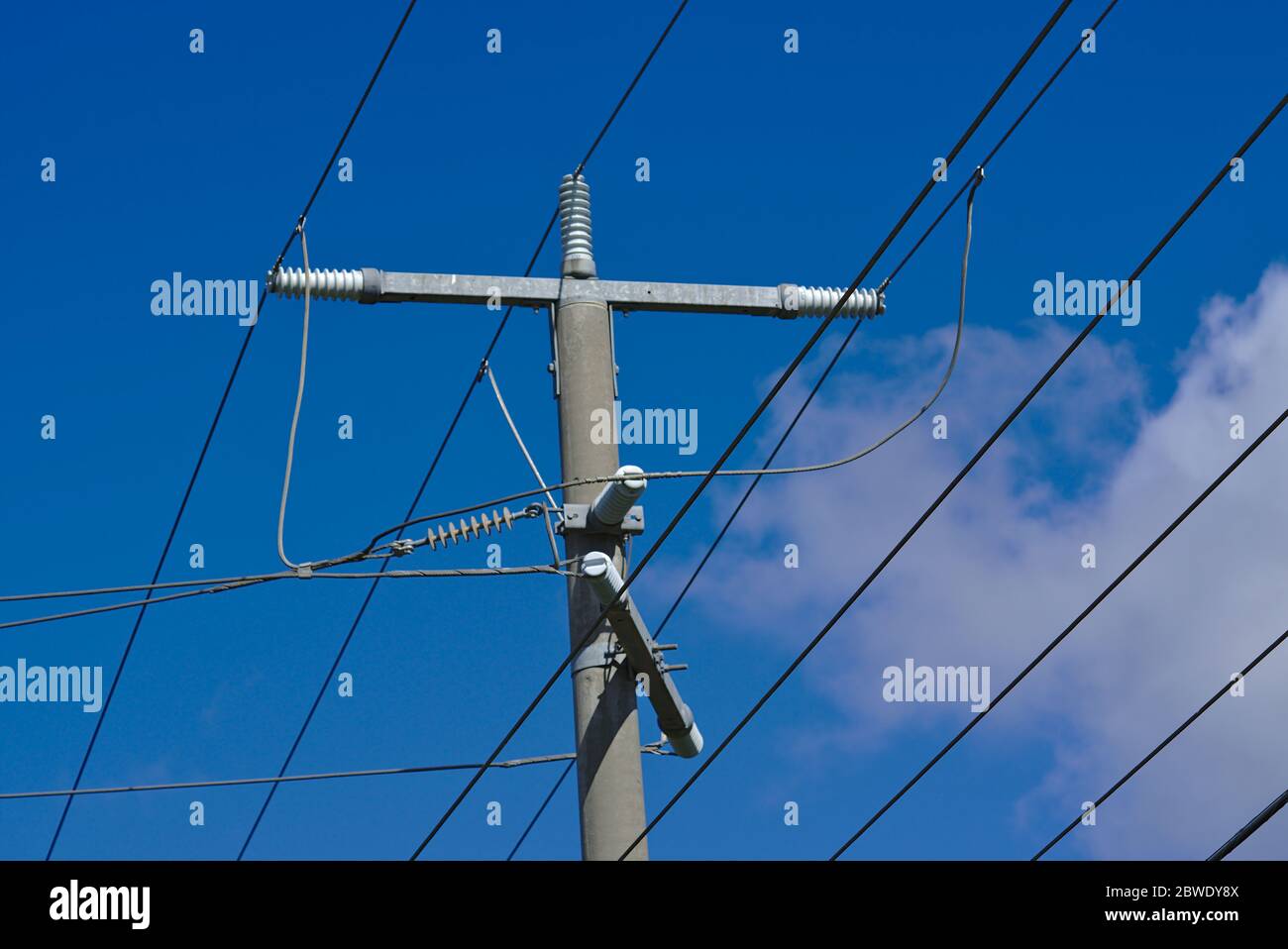 Distant view of high voltage power lines electric post with blue sky ...