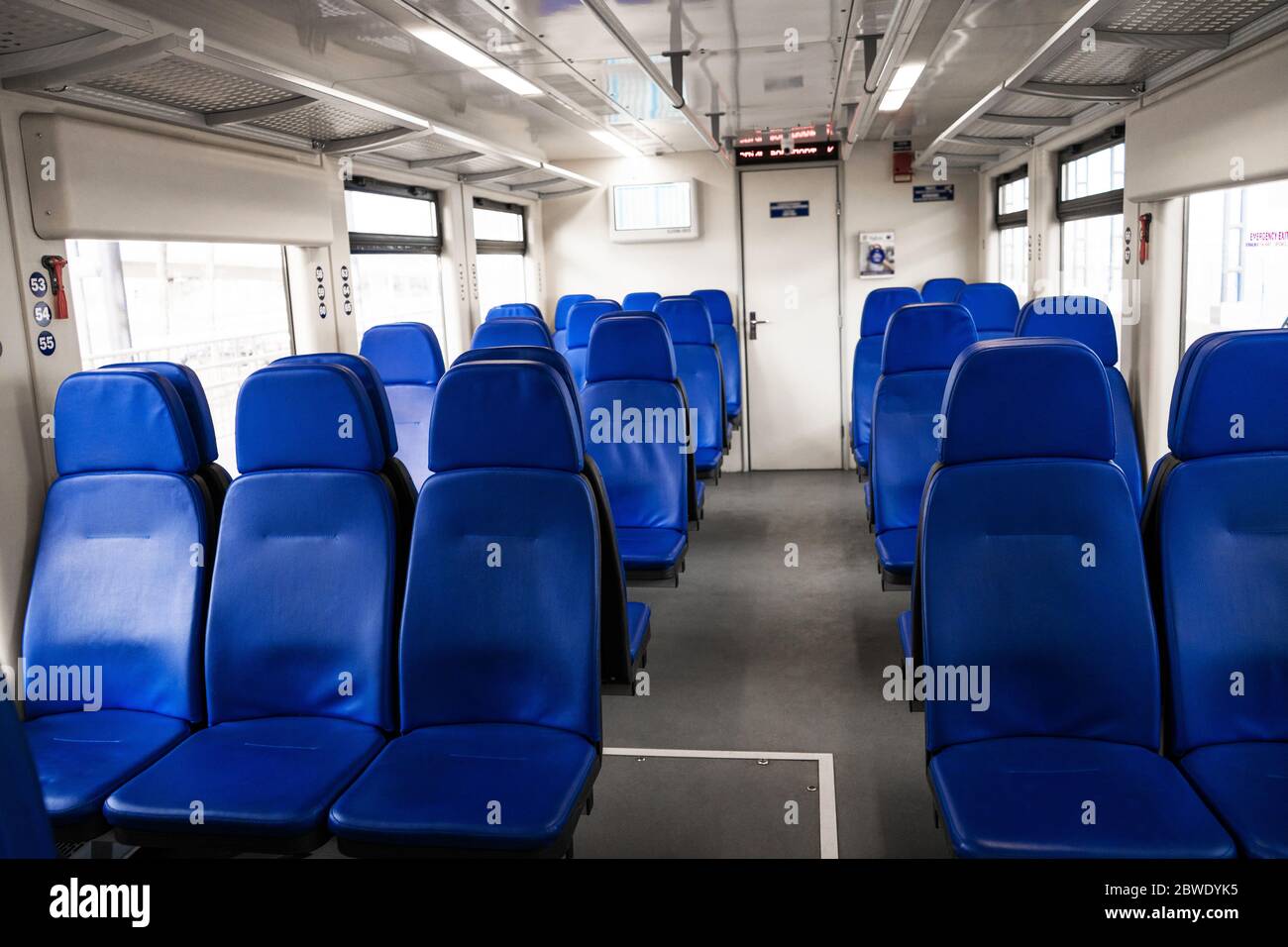 The interior of the transfer train to the airport. Rows of blue ...