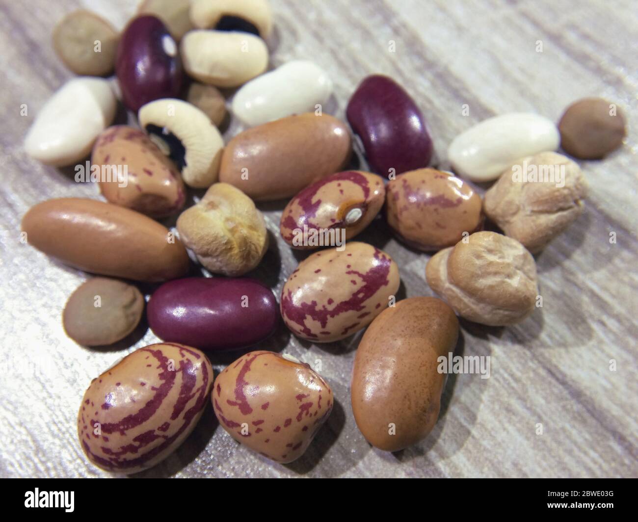 All kinds of beans on wooden background. red beans, broad beans, lentils, black-eyed pea or cowpea, Navy bean, local bean, cheakpea beans, pinto bean. Stock Photo
