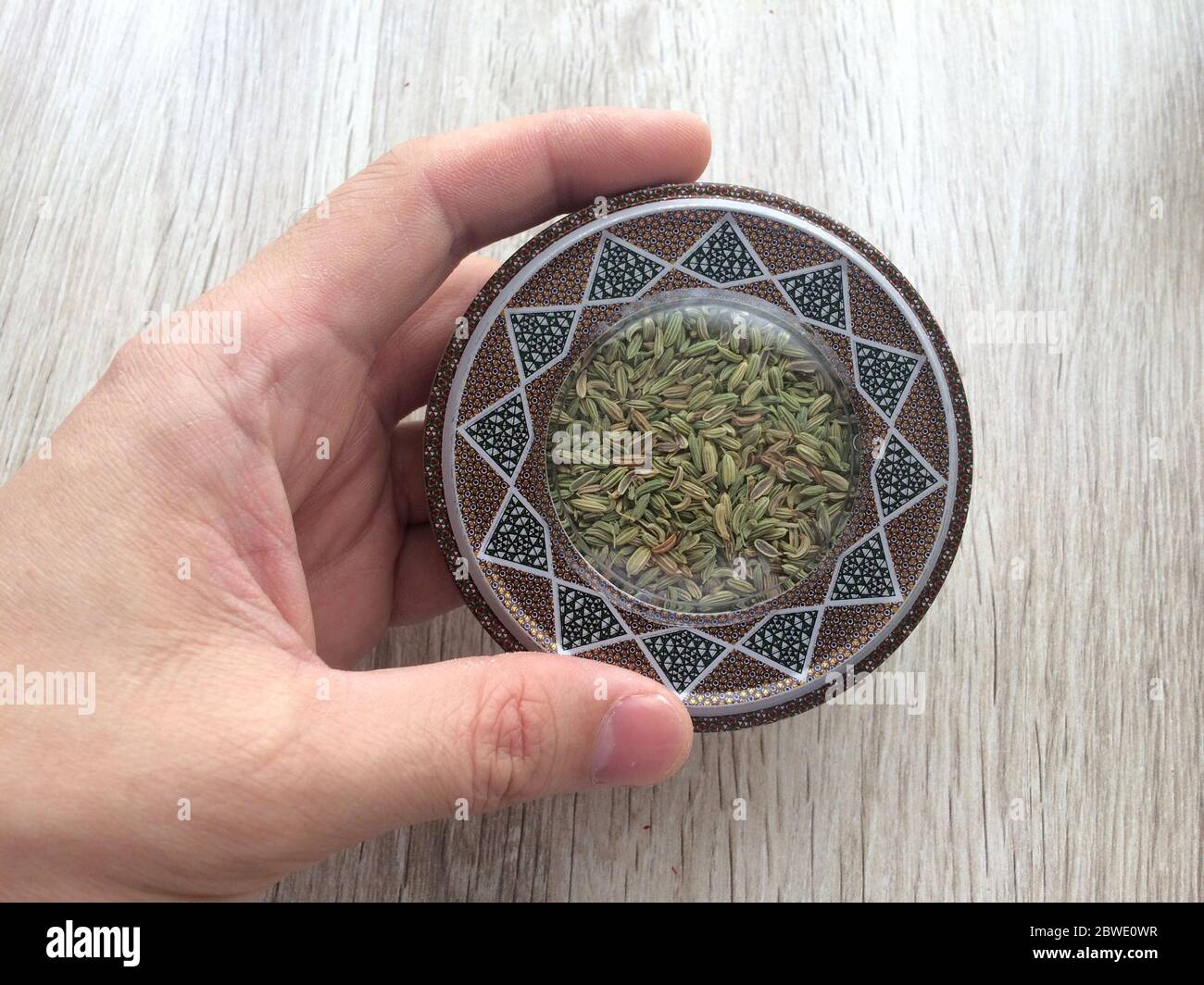 Raw dried fennel seeds or variyali or Foeniculum vulgare in male hand ...
