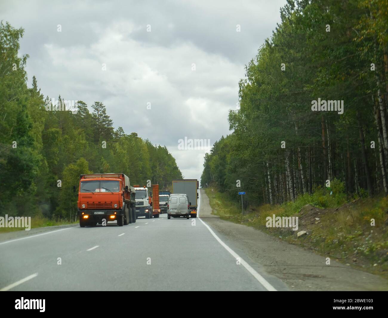 chelyabinsk, russia 06 06 2019: Ural mountains road with Russian cars. Cross the road through the jungle. Stock Photo
