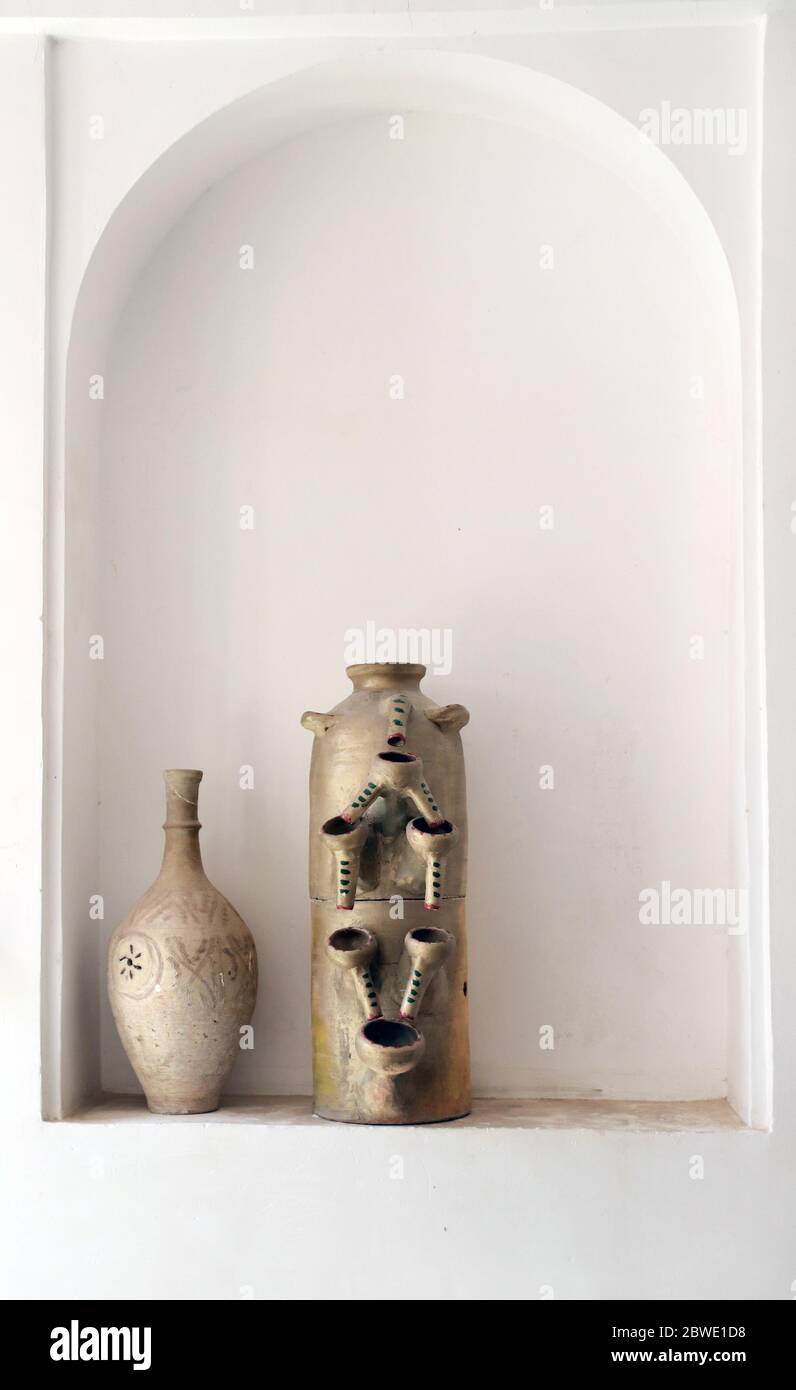 Traditional iranian wine jugs. Old clay chatty on shelf in wall arch Stock Photo