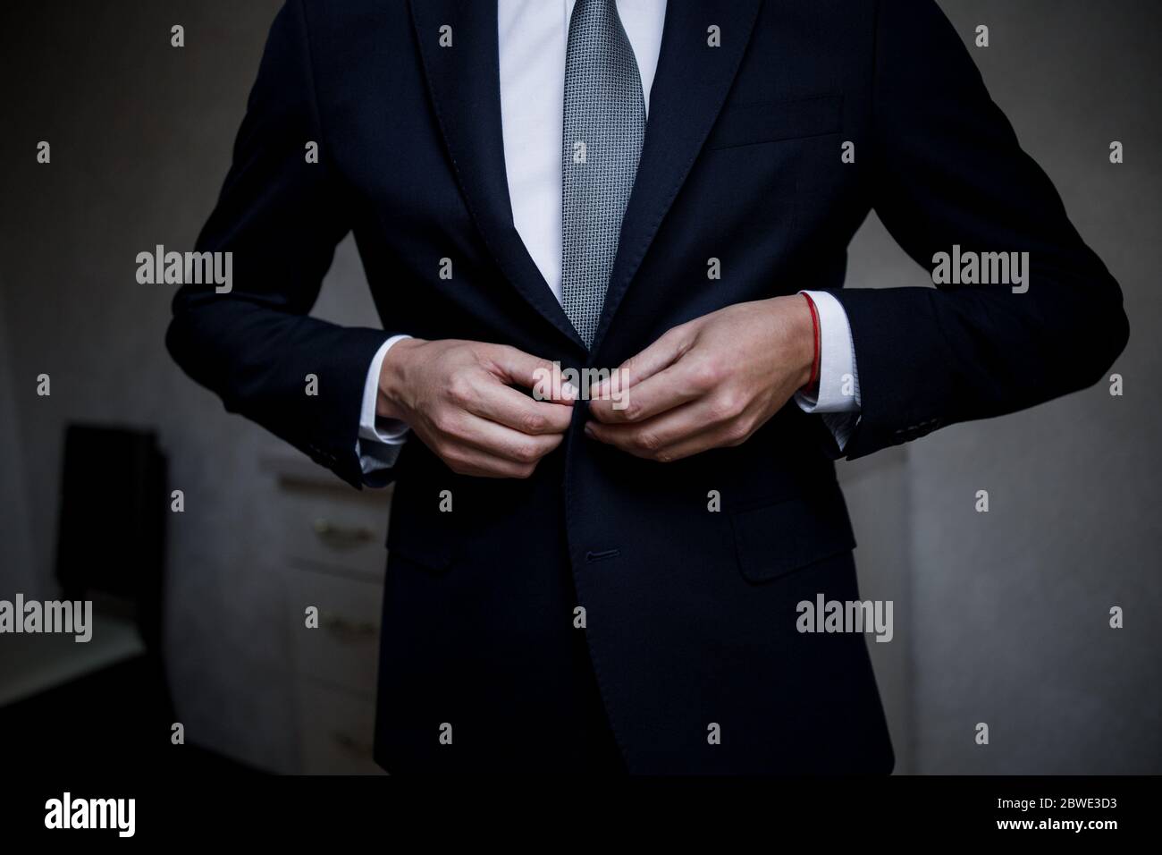 man puts on suit in the room Stock Photo